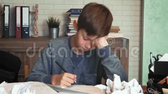 沮丧的小男孩厌倦了他的家庭作业把纸弄皱了视频的预览图