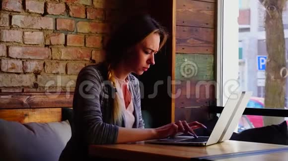 女抄写者在咖啡馆用笔记本写文章视频的预览图