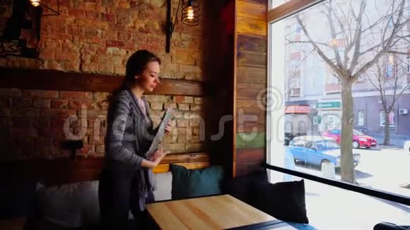 漂亮的女人带着笔记本电脑参观咖啡馆享受社交网络中的聊天视频的预览图