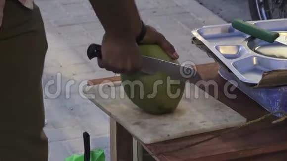 男人从一个年轻的新鲜椰子上切下来马尔代夫视频部分模糊视频的预览图