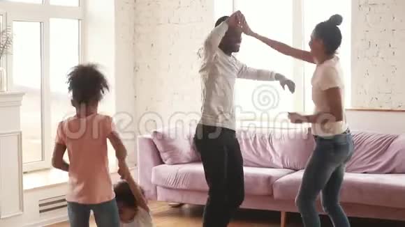 快乐的非裔美国人家庭父母和孩子在家跳舞视频的预览图