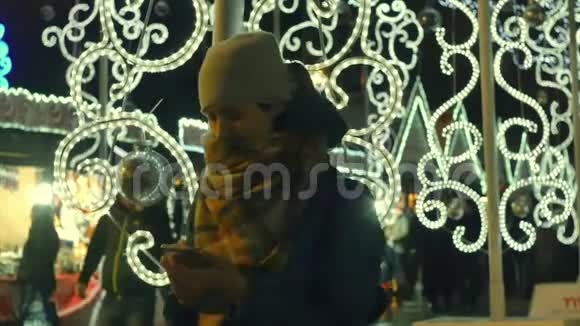 在圣诞节市场上年轻女子用智能手机自拍视频的预览图