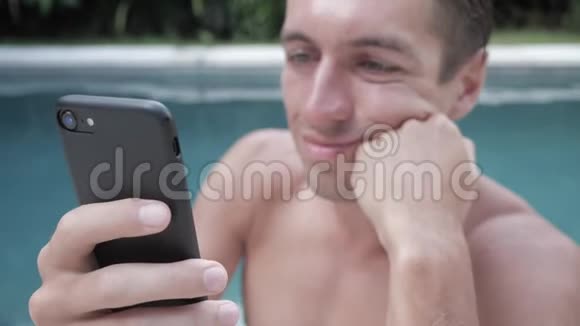 暑假在游泳池里用智能手机的年轻人视频的预览图
