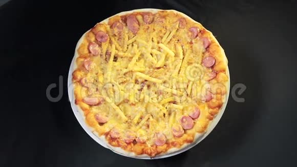 带有奶酪和香肠的披萨从顶部可以看到黑色背景视频的预览图