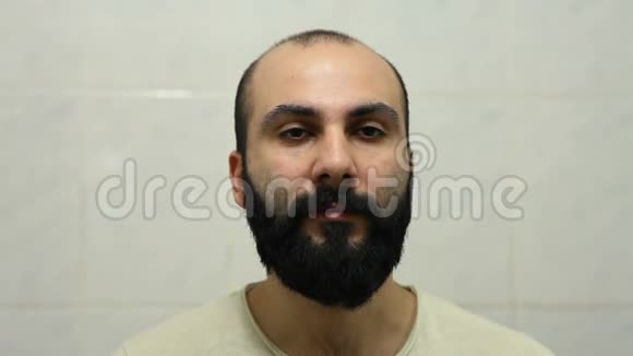 亚美尼亚男子用电动剃须刀刮胡子视频的预览图