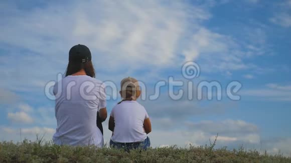 一家人在草地上举起手梦想着幸福的家庭观念生活方式自由视频的预览图