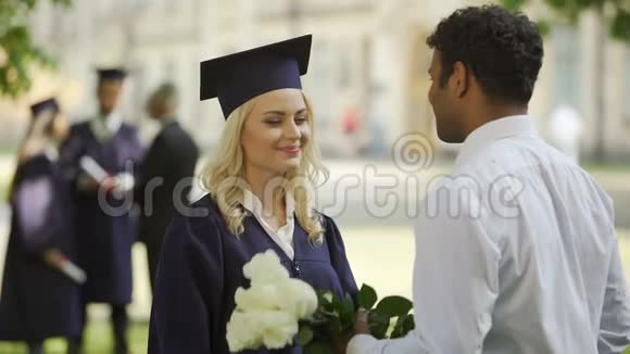 男朋友送花给他的女毕业生拥抱特殊场合视频的预览图