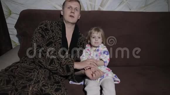 小女儿和她的父亲一起看充满激情的有趣电影视频的预览图
