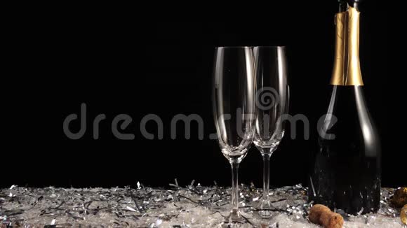 好香槟酒两个空杯子从香槟酒在白色的雪和黑色的背景配有起泡葡萄酒的长笛手拿视频的预览图