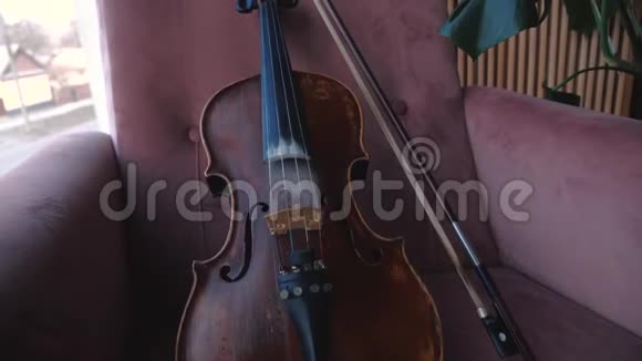 小提琴与弓躺椅在房间靠近窗户稳住摄像机视频的预览图