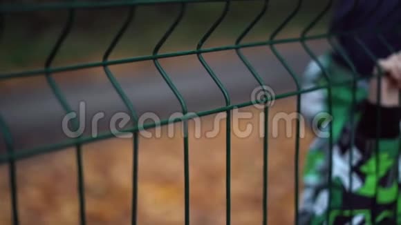 被遗弃了孤独的男孩在篱笆后秋天的季节视频的预览图