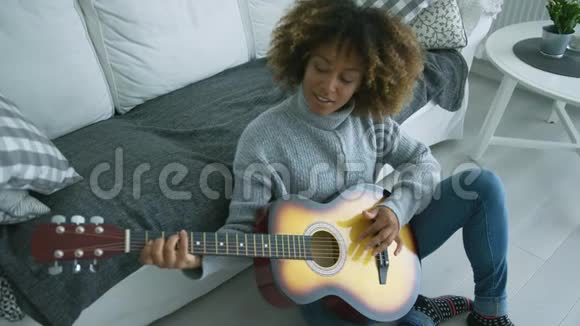 放松的女人在家弹吉他视频的预览图