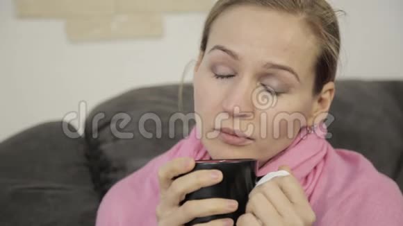 生病的女人用餐巾纸擦拭他的鼻子并被温暖的皮肤遮挡视频的预览图