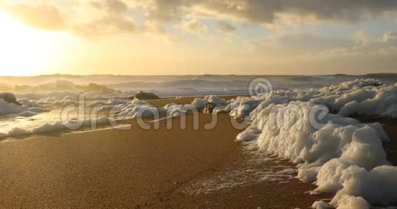 日落时海滩上的海浪泡沫视频的预览图