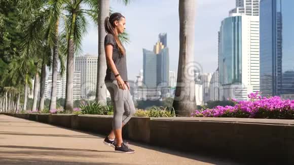 在晨间公园跑步前做热身运动的混合性运动女子4K慢运动曼谷视频的预览图
