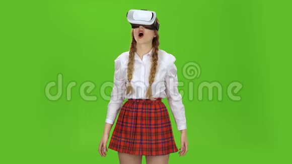 戴着虚拟现实眼镜的女孩在玩绿色屏幕视频的预览图