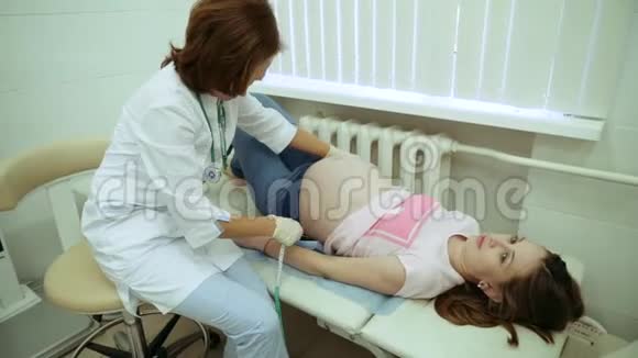 医生用测量仪测量怀孕女孩的腹部视频的预览图