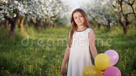 一个小女孩在盛开的苹果园的肖像视频的预览图