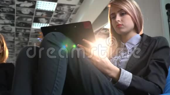 一个穿西装的长发女人倾听别人的声音在平板电脑里写字视频的预览图