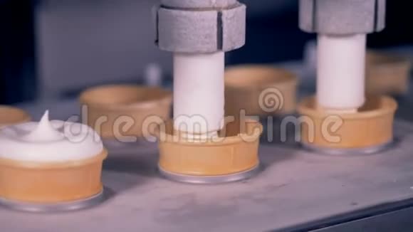 两个自动管将奶油填充到晶片杯中视频的预览图