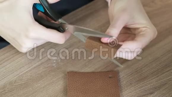 特写女的手用剪刀剪一块皮准备缝纫裁剪视频的预览图