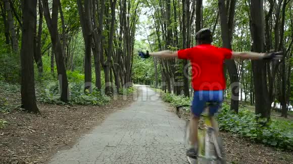 骑着黄色自行车的红蓝色制服的自行车从镜头前移开露出双手视频的预览图