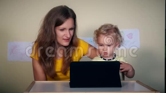 家庭主妇和女儿玩平板电脑视频的预览图