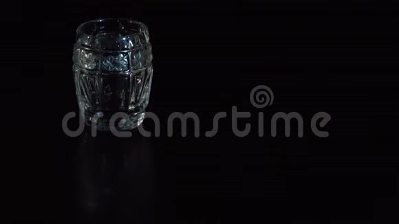 伏特加被倒入黑色背景的玻璃杯中视频的预览图