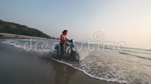 滑板车骑在沙滩上的海水溅水视频的预览图