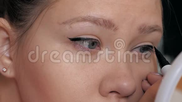美少女化妆的特写用眼线眼线画箭视频的预览图