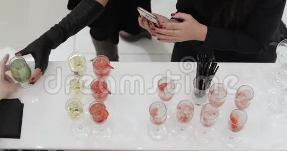 女人在智能手机鸡尾酒上拍照视频的预览图