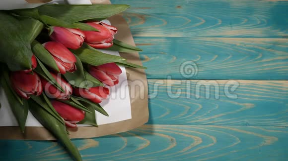 我需要你的留言条和郁金香花束在木桌上的俯视图恋爱关系的概念圣视频的预览图