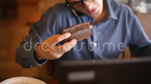 年轻英俊的商人戴着眼镜手提电脑打电话记笔记和搜索信息视频的预览图