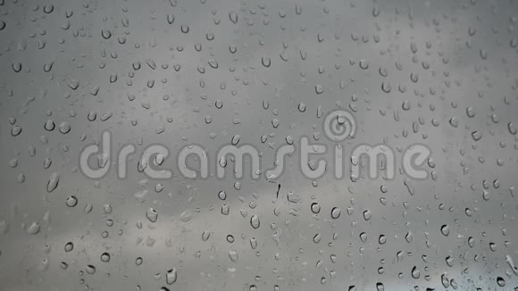 窗玻璃上大量的雨滴水流迅速地从玻璃上流下来视频的预览图