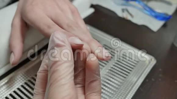 用指甲油覆盖凝胶女人手在修指甲视频的预览图