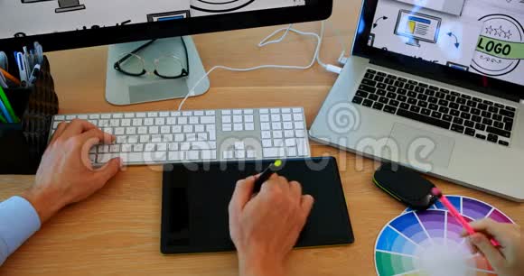 平面设计师在办公桌上工作视频的预览图
