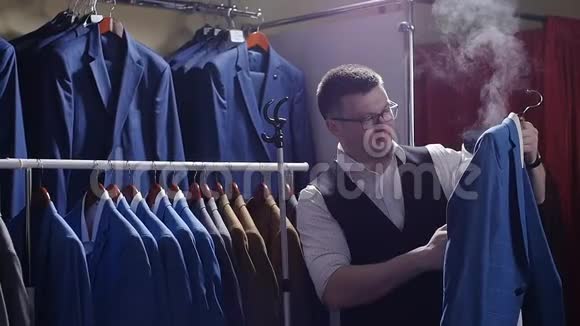 服装店里的男卖家脱下他的夹克准备出售视频的预览图