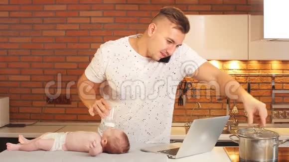 年轻的父亲和一个小儿子在厨房上学年轻父母家庭教育的概念视频的预览图