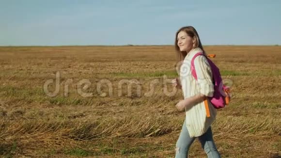 年轻的女人带着粉红色的背包走路视频的预览图