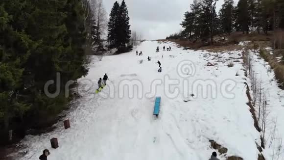 鸟瞰冬季白天滑雪板沿着斜坡行驶冬天滑雪者在滑雪场的山坡上尽情享受视频的预览图