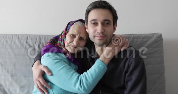 老奶奶和小孙子坐在沙发上拥抱视频的预览图