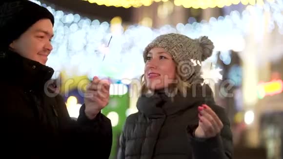 爱的夫妇带着微笑的火花看着冬天的城市的眼睛圣诞快乐和新年的概念视频的预览图