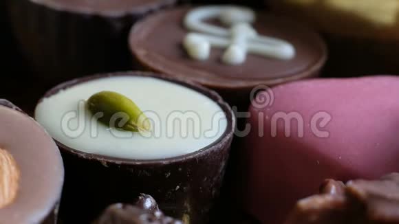 女人从盒式美味的甜点背景中选择各种巧克力关门视频的预览图