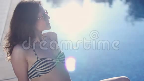 热女性享受乐趣在阳光明媚的海滩放松波光粼粼的水视频的预览图