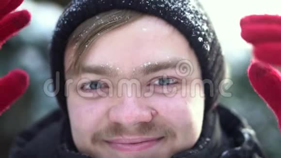一幅英俊开朗的男人的肖像他留着胡子穿着冬天的衣服脸上挂着雪为了金发女郎视频的预览图