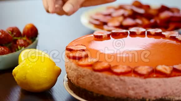 女人用草莓慕斯蛋糕装饰的手视频的预览图