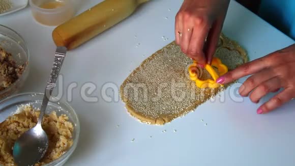 小饼干的准备那个女人在模具的帮助下挤出来在卷出来的时候试着做饼干的底座视频的预览图