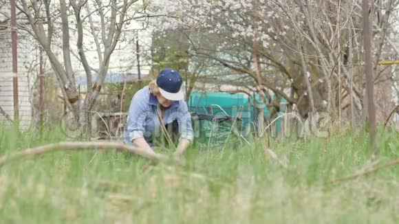 园丁妇女在花园后院打扫干草视频的预览图