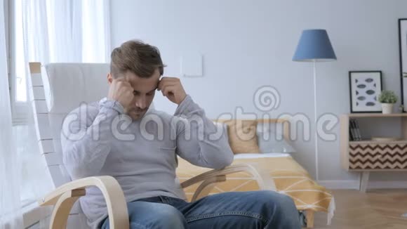 头痛紧张的中年男人坐在休闲椅上视频的预览图