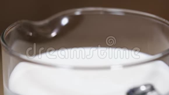 新鲜的牛奶一串一串地倒进玻璃瓶溅起水花视频的预览图